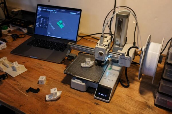 Bambu Lab A1 Mini 3D printer on a maker desk mid-print — best 3D printer for beginners 2026